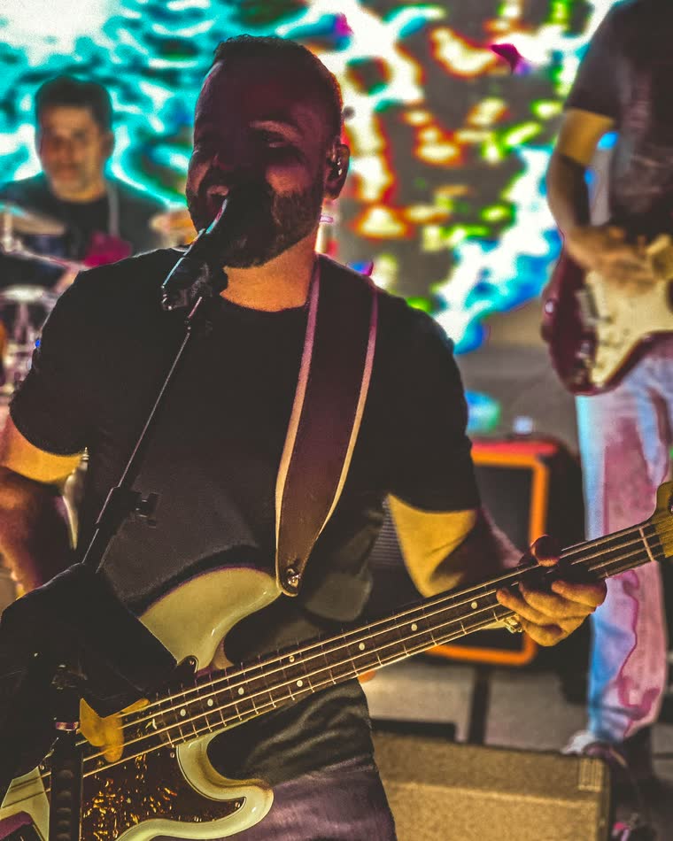 Bernie singing and playing bass on stage