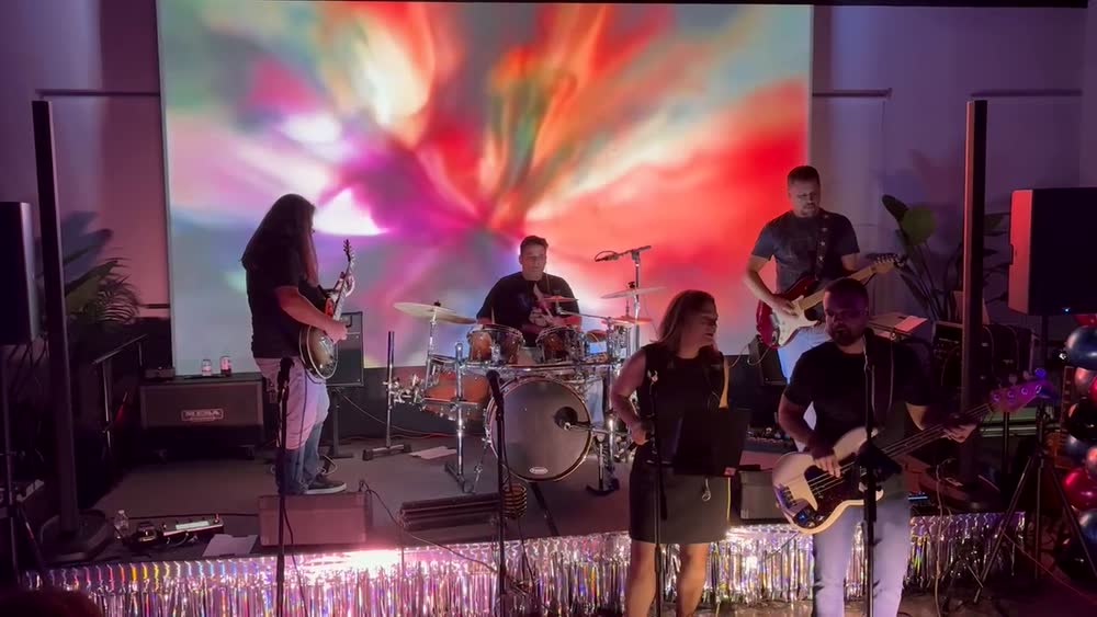 The Pollies mid-set under red and orange stage lights